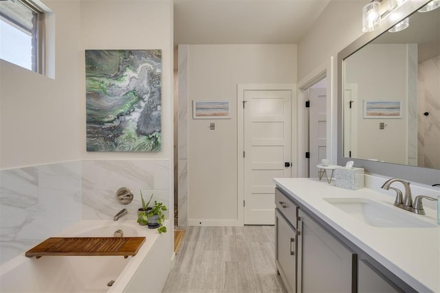 full bathroom with vanity and a bath