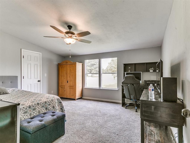 bedroom featuring a ceiling fan, baseboards, carpet, and a textured ceiling