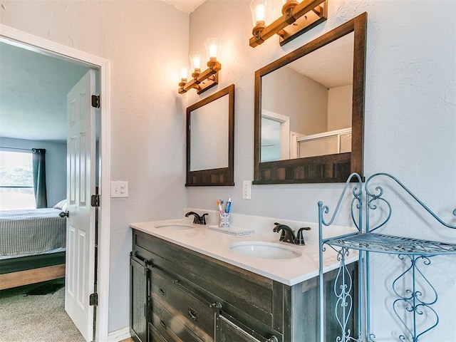 ensuite bathroom with connected bathroom, double vanity, and a sink