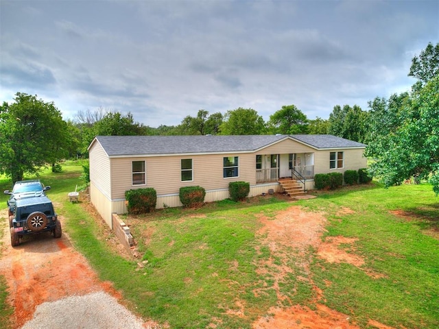 view of front of property featuring a porch, roof with shingles, driveway, and a front yard