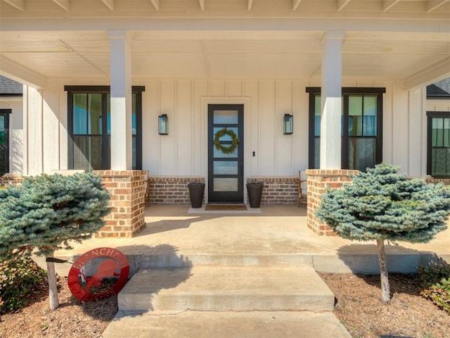 entrance to property featuring board and batten siding and covered porch