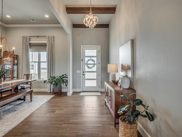 entrance foyer featuring visible vents, dark wood finished floors, beam ceiling, baseboards, and a notable chandelier