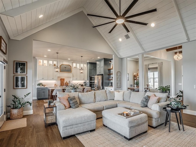 living room with high vaulted ceiling, baseboards, and wood finished floors