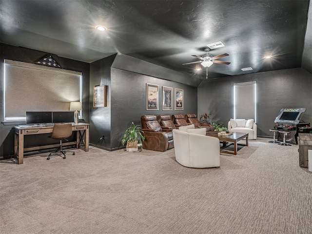 carpeted living room featuring baseboards, a ceiling fan, and a textured wall