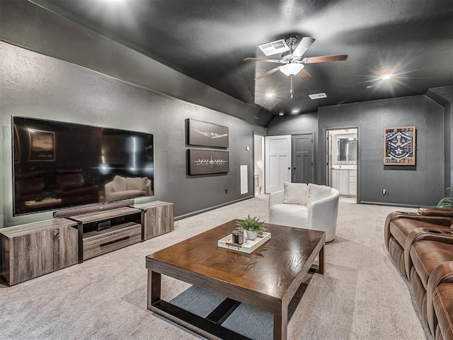 carpeted living area with ceiling fan, vaulted ceiling, and a textured wall