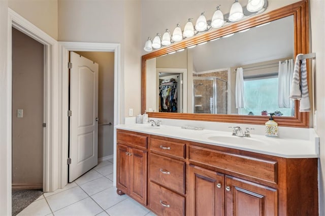 116 Mission Hills Dr, Guthrie, OK 73044 - bathroom with a shower stall, tile patterned flooring, double vanity, a walk in closet, and baseboards