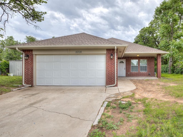 ranch-style house with brick siding, driveway, roof with shingles, and a garage