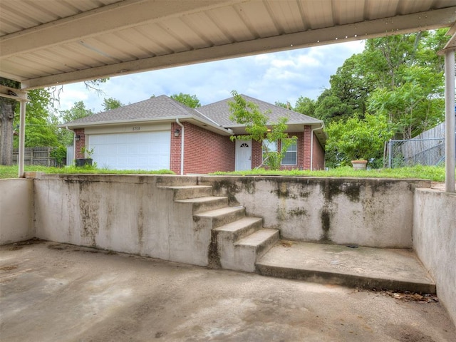view of patio featuring fence and a garage
