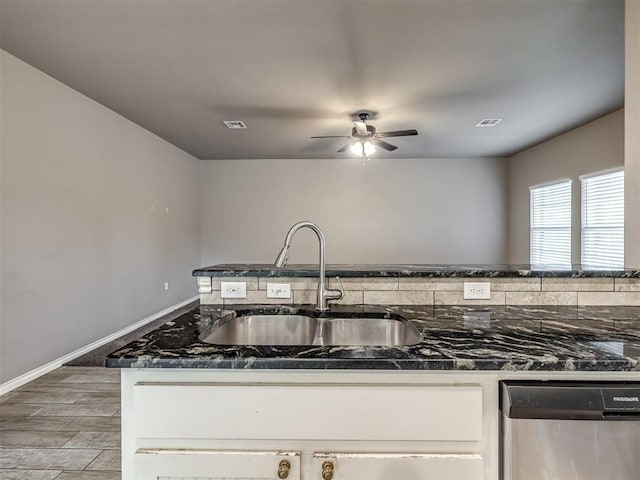 kitchen featuring ceiling fan, a sink, light wood finished floors, baseboards, and stainless steel dishwasher