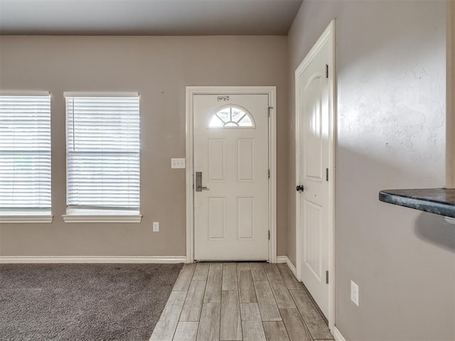 foyer entrance with baseboards and light wood-type flooring