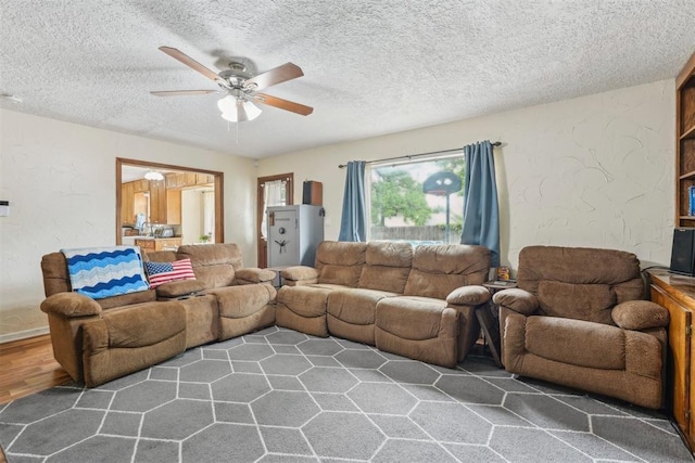 living area featuring a textured ceiling, ceiling fan, and wood finished floors