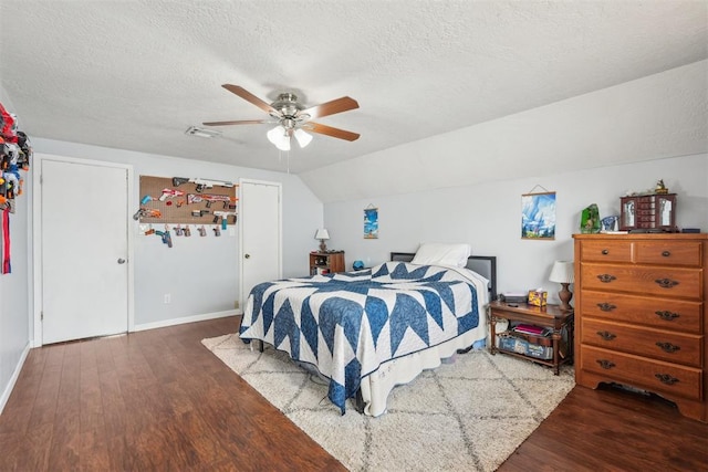 bedroom featuring a textured ceiling, baseboards, wood finished floors, and lofted ceiling