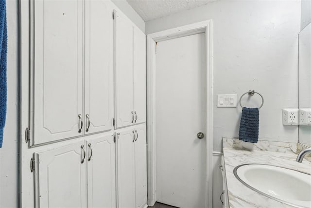 bathroom with a textured ceiling and vanity