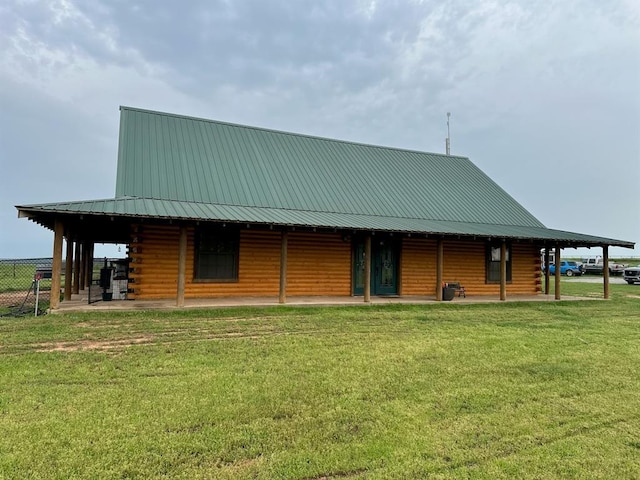 exterior space featuring a lawn, log siding, and metal roof