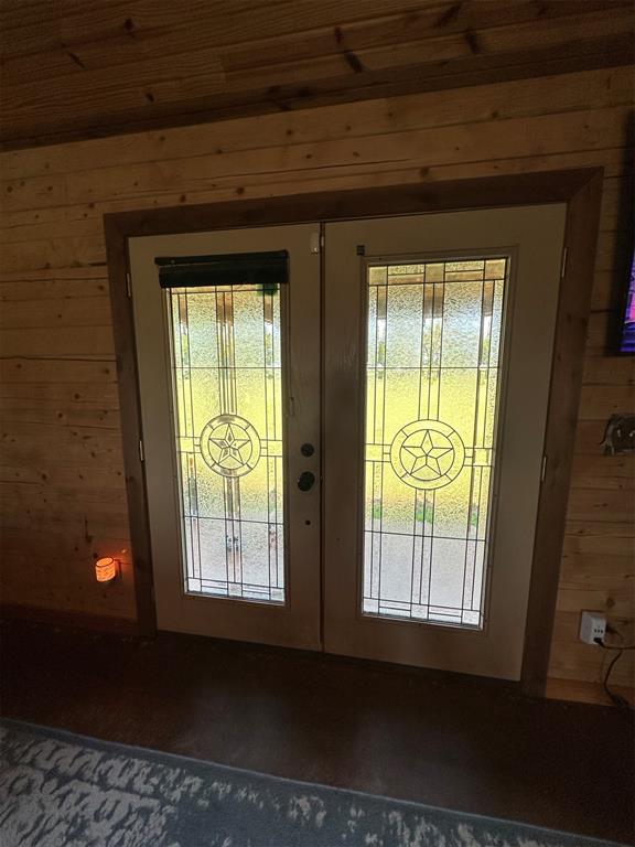 entryway featuring french doors and wood walls