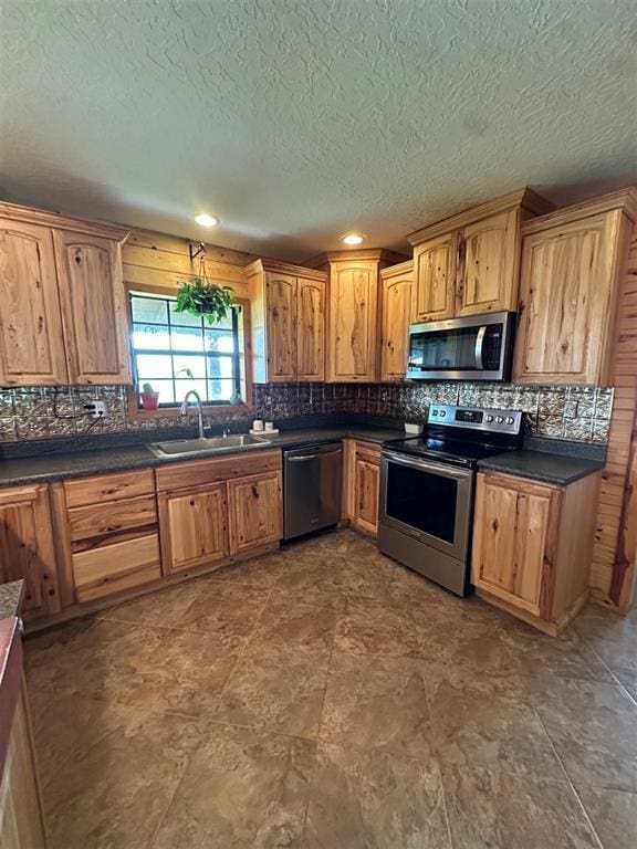 kitchen with a sink, decorative backsplash, dark countertops, and stainless steel appliances