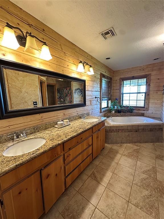 full bath with a sink, tile patterned flooring, a bath, and visible vents