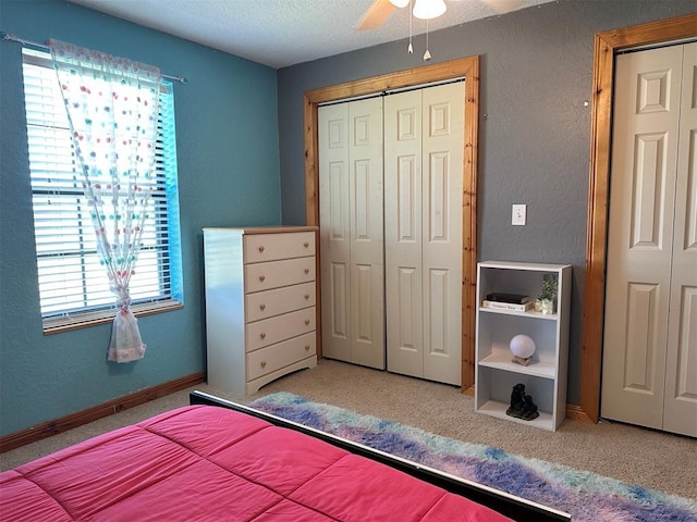 carpeted bedroom with a textured ceiling, a textured wall, and multiple windows