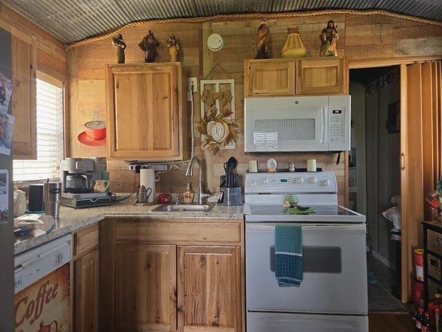kitchen featuring white appliances and a sink