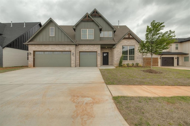 craftsman house featuring board and batten siding, driveway, brick siding, a front yard, and an attached garage
