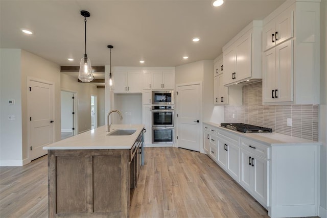 kitchen with a sink, appliances with stainless steel finishes, white cabinetry, recessed lighting, and light wood-style flooring