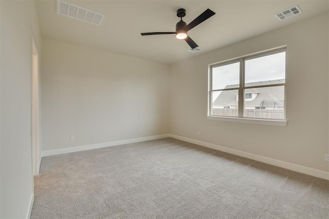 carpeted spare room with ceiling fan and baseboards