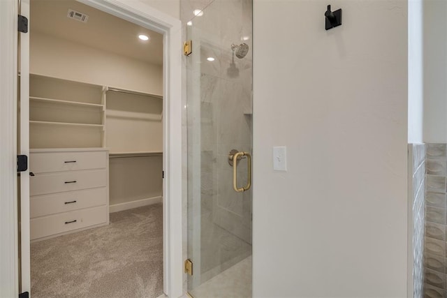 full bathroom featuring a walk in closet, a shower stall, and recessed lighting