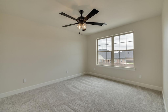 empty room featuring plenty of natural light, baseboards, carpet, and ceiling fan