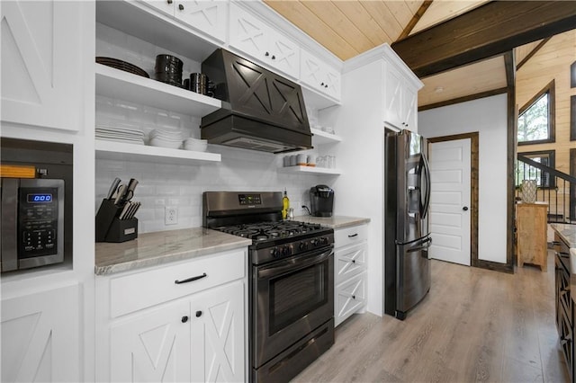 kitchen featuring stainless steel range with gas cooktop, premium range hood, open shelves, black refrigerator with ice dispenser, and backsplash