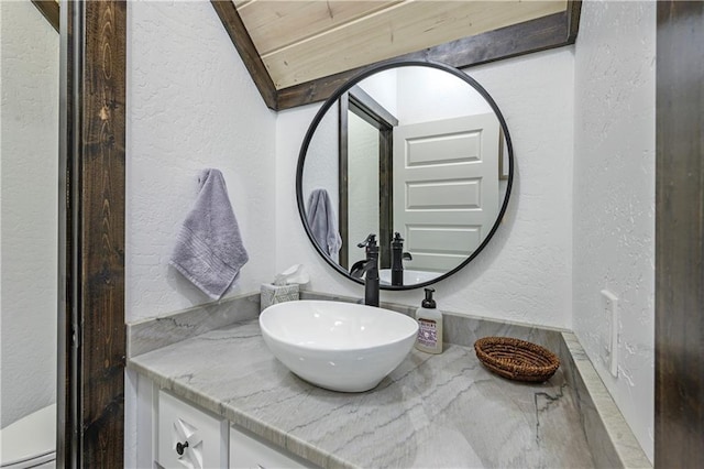 bathroom featuring vanity and a textured wall
