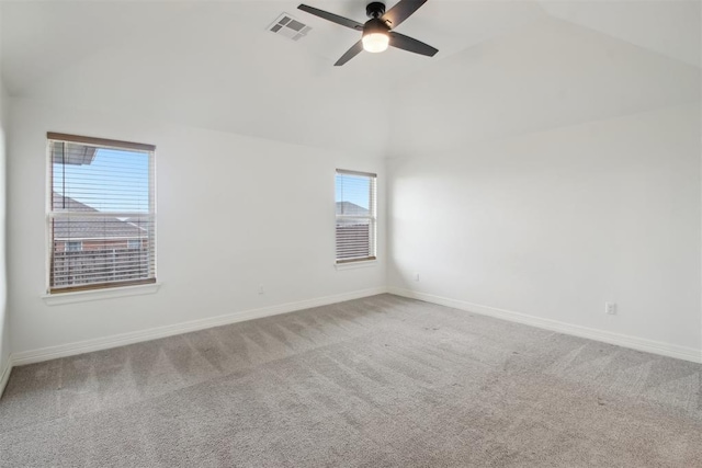 carpeted spare room with baseboards, ceiling fan, vaulted ceiling, and visible vents