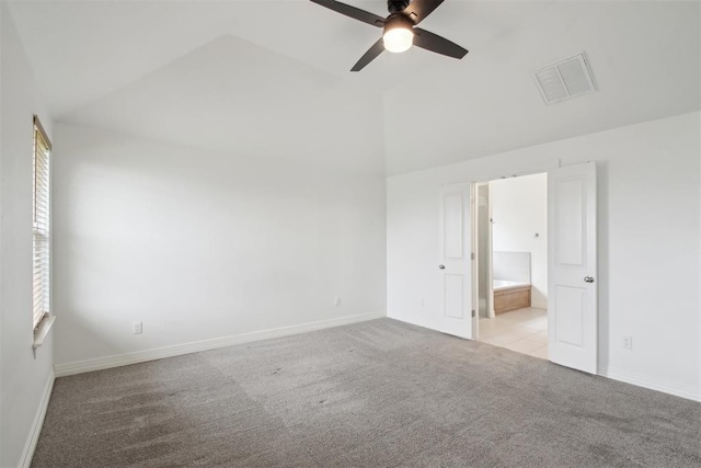 unfurnished bedroom featuring ensuite bath, high vaulted ceiling, carpet, baseboards, and visible vents