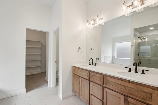 full bath featuring a sink, a stall shower, toilet, and tile patterned floors