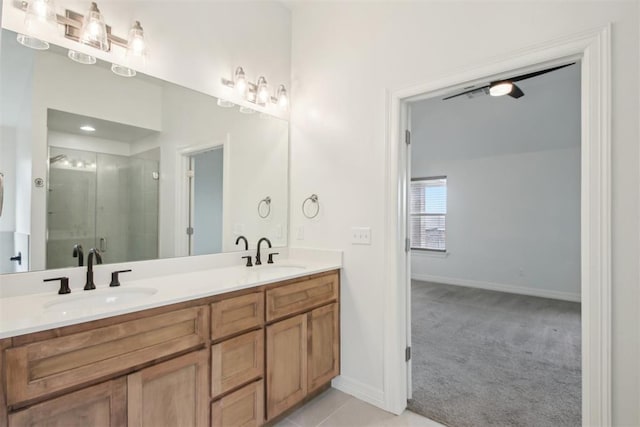 bathroom featuring double vanity, a sink, baseboards, and a stall shower
