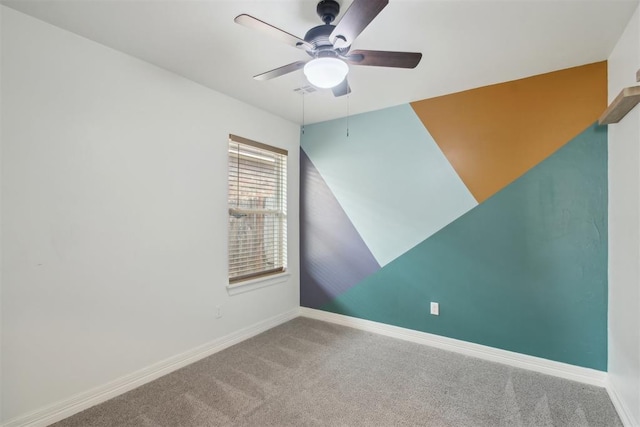 spare room with carpet floors, a ceiling fan, and baseboards
