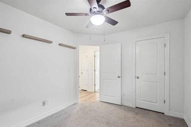 unfurnished bedroom featuring baseboards, ceiling fan, and light carpet