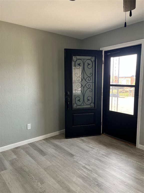 foyer entrance with baseboards and light wood finished floors