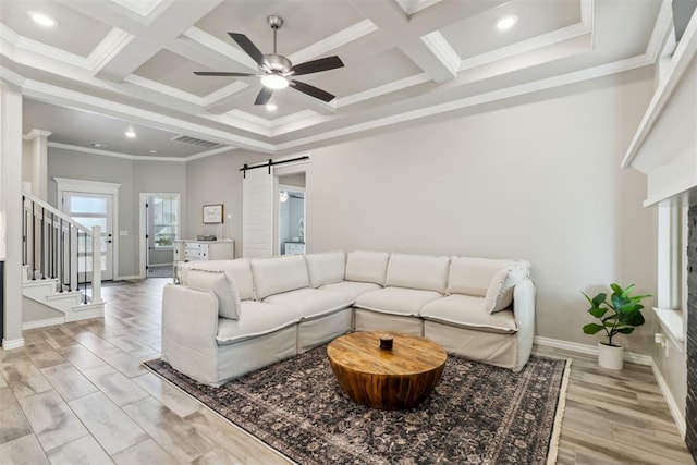living area featuring visible vents, a barn door, coffered ceiling, and stairway