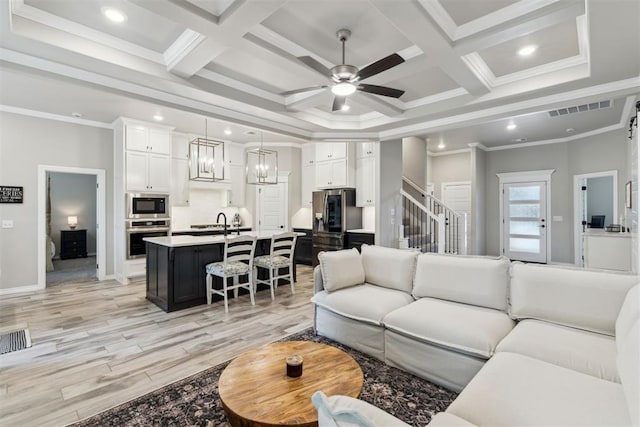 living area with visible vents, coffered ceiling, ceiling fan, and light wood-type flooring