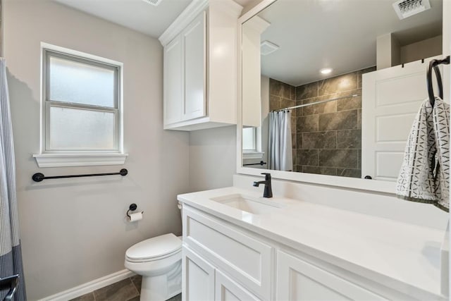 bathroom featuring visible vents, vanity, baseboards, toilet, and tiled shower