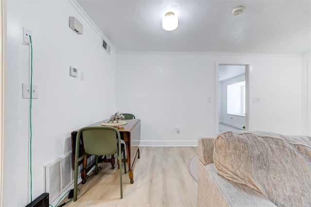 office area featuring crown molding, light wood-style flooring, and visible vents