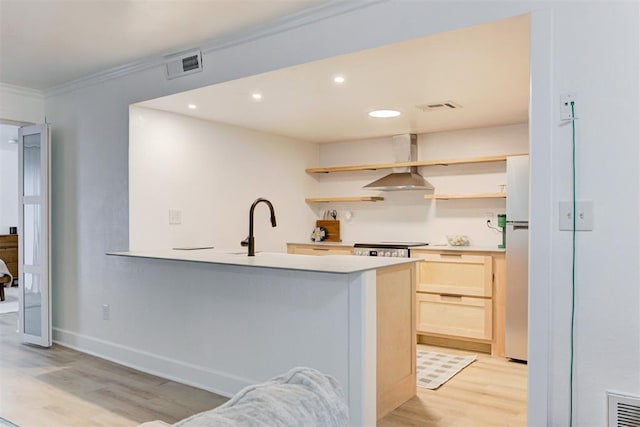 kitchen featuring visible vents, open shelves, light brown cabinetry, wall chimney exhaust hood, and light wood-style flooring