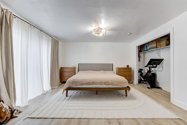 bedroom with baseboards and light wood finished floors