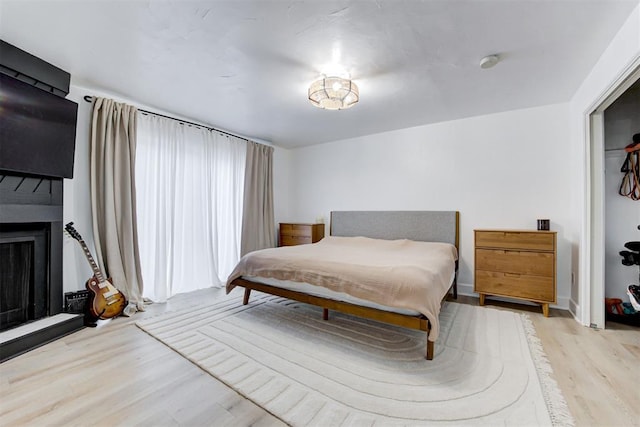 bedroom with wood finished floors and a fireplace