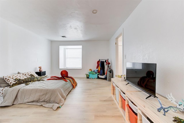 bedroom with light wood-type flooring and visible vents