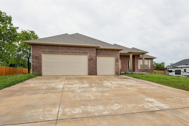 view of front facade featuring fence, an attached garage, a front lawn, brick siding, and driveway