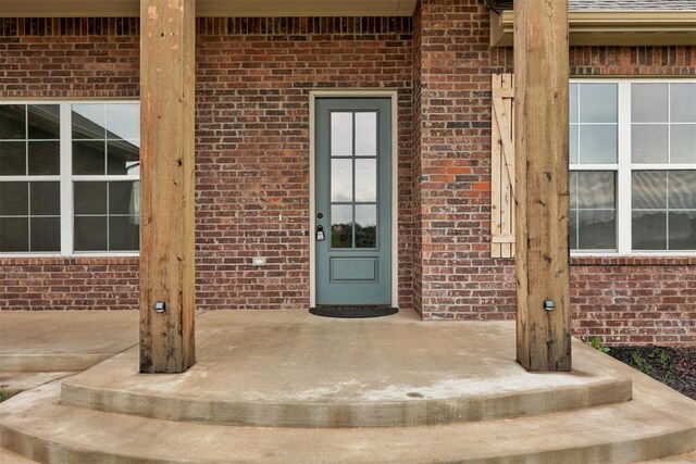 view of exterior entry featuring brick siding