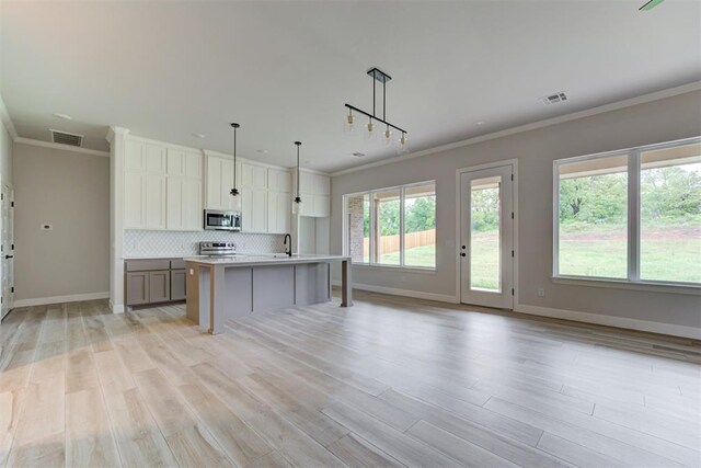 kitchen featuring visible vents, ornamental molding, baseboards, and stainless steel appliances