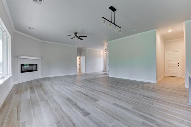 unfurnished living room with a ceiling fan, baseboards, and visible vents