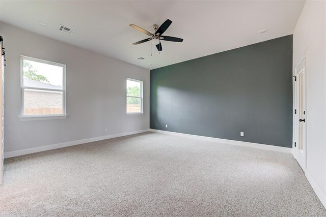 empty room with visible vents, a ceiling fan, carpet, and baseboards
